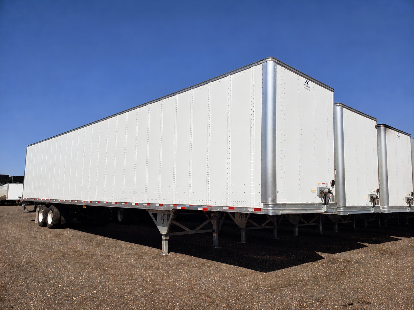 White dry van semi-trailers parked in a rental yard
